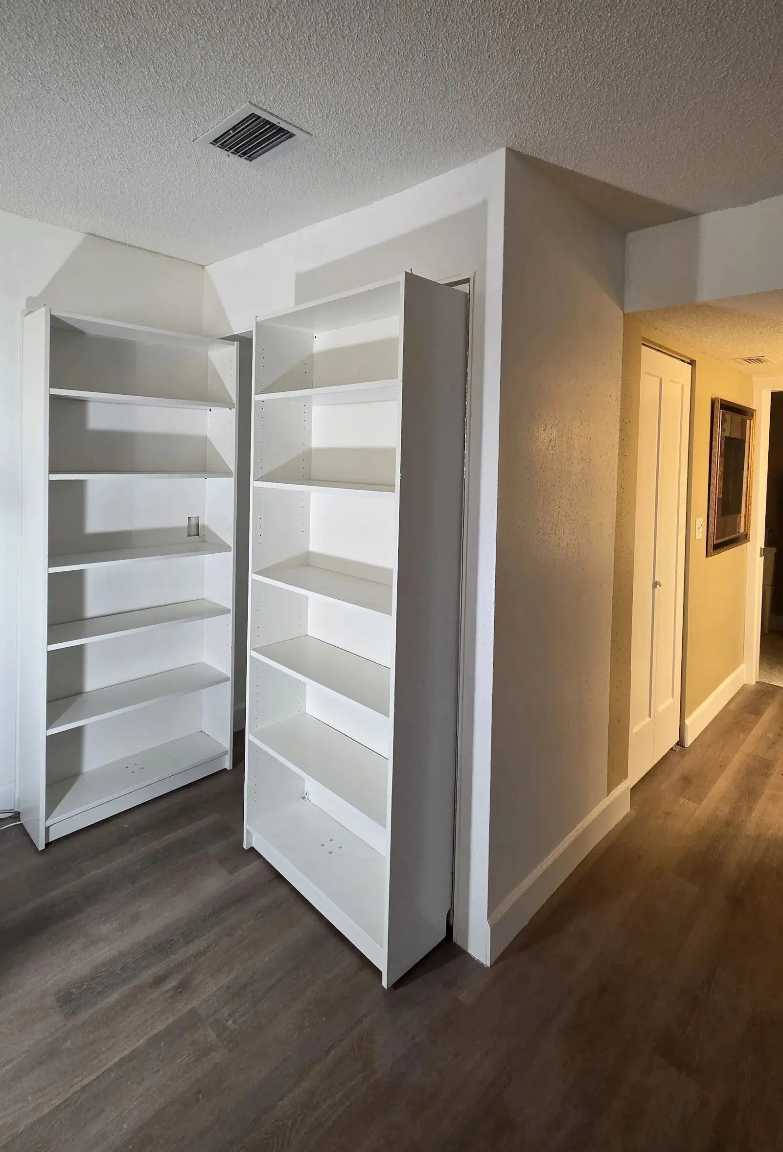 Two white custom shelving units installed in a closet alcove in Bradenton