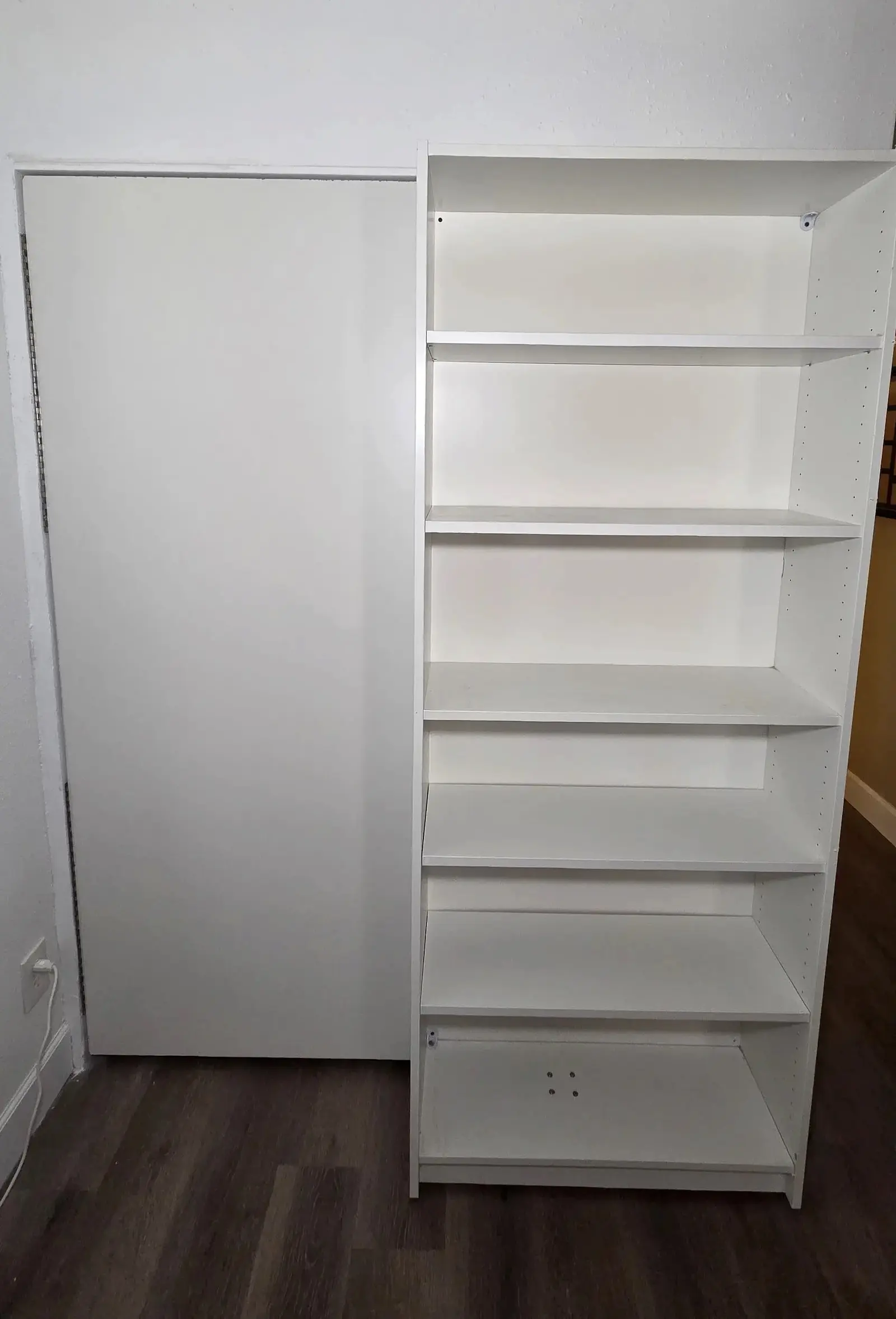 Front view of a white custom shelving unit beside a closed closet door in Bradenton