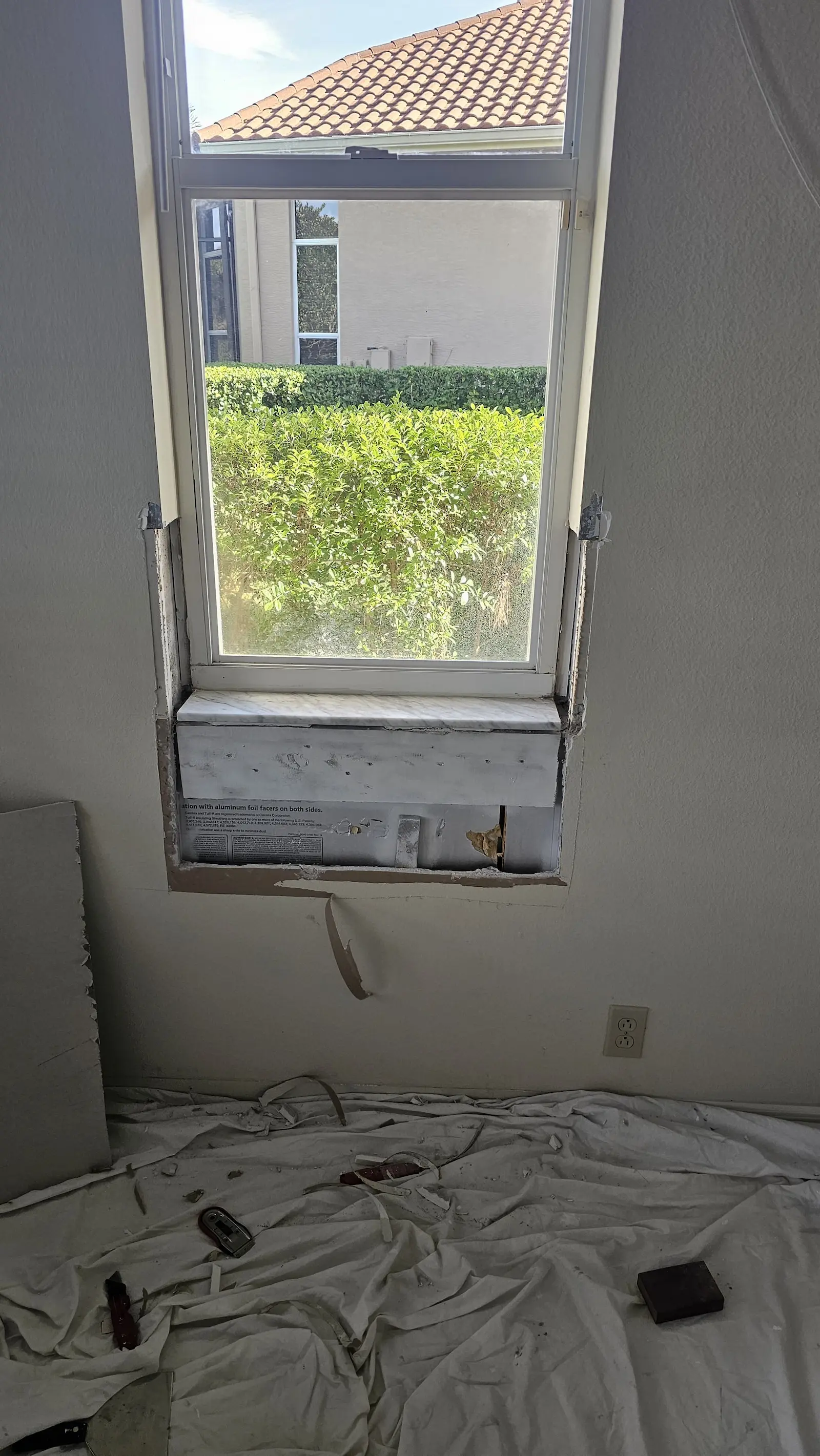 Damaged interior window area before drywall and trim repair.