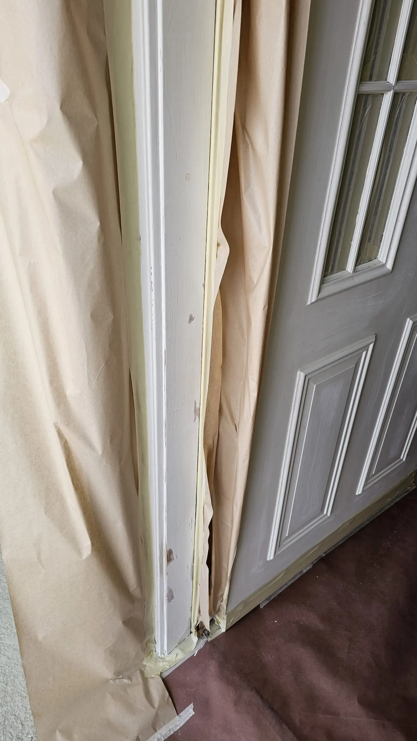 Surface preparation and masking before repainting an exterior front door in Sarasota, Florida.